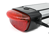 Il caricabatterie della batteria compatibile con Gazelle Innergy Gold è collegato sul lato della batteria. La luce posteriore è chiaramente visibile.
